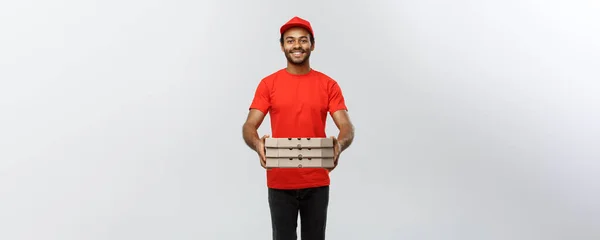 Lieferkonzept - Portrait des hübschen afroamerikanischen Pizzaboten. Isoliert auf grauem Studiohintergrund. Kopierraum. — Stockfoto