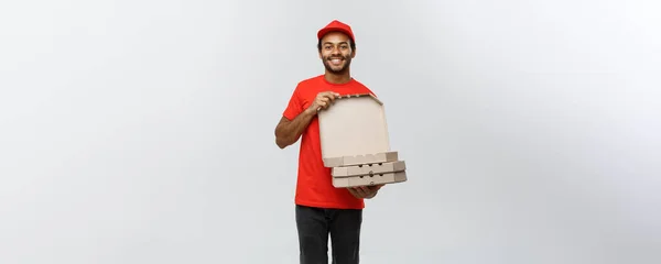 Leverans Concept - Porträtt av snygga afroamerikanska Pizza leverans man. Isolerad på Grey Studio Bakgrund. Kopiera utrymme. — Stockfoto