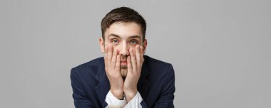 İş kavramı - portre yakışıklı yakışıklı iş adamı gülümseyen ve ciddi ve depresif ifade ile çalışma ofisinde siting takım elbiseli. Beyaz arka plan izole. Kopya alanı.