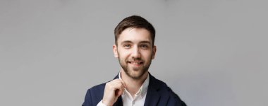 İş kavramı - portre yakışıklı mutlu yakışıklı iş adamı gülümseyen ve çalışma ofisinde siting takım elbiseli. Beyaz arka plan.