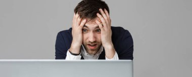 İş kavramı - portre yakışıklı stresli iş adamı iş laptop arıyorum takım elbise şoka girmiş. Beyaz arka plan.