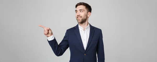 Geschäftskonzept - Porträt gutaussehender Geschäftsmann selbstbewusstes Lächeln, das mit dem Finger zeigt. weißer Hintergrund. — Stockfoto