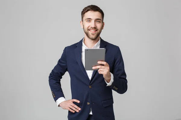 Geschäftskonzept - Porträt schöner Geschäftsmann spielt digitales Tablet mit lächelndem selbstbewusstem Gesicht. weißer Hintergrund. Kopierraum. — Stockfoto