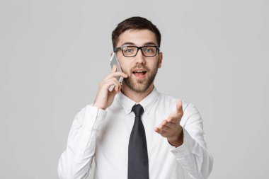 İş kavramı - portre genç yakışıklı kızgın iş adam kameraya bakarak telefon uymak. Beyaz arka plan.