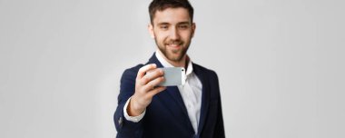 İş kavramı - yakışıklı iş adamı kendini bir selfie ile smartphone. Beyaz arka plan.