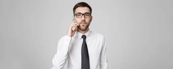Business Concept - Portrait young handsome angry business man in suit talking on phone looking at camera. White background. — Stock Photo, Image
