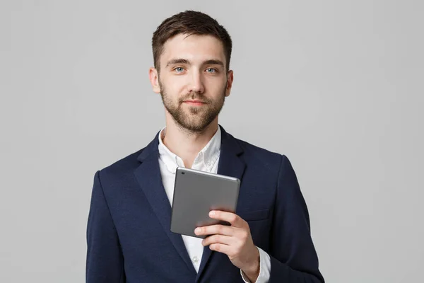 Geschäftskonzept - Porträt schöner Geschäftsmann spielt digitales Tablet mit lächelndem selbstbewusstem Gesicht. weißer Hintergrund. Kopierraum. — Stockfoto