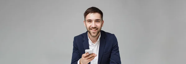 Affärsidé - porträtt stilig glad stilig affärsman i kostym spela moblie telefon och leende med laptop i arbete office. Vit bakgrund. — Stockfoto