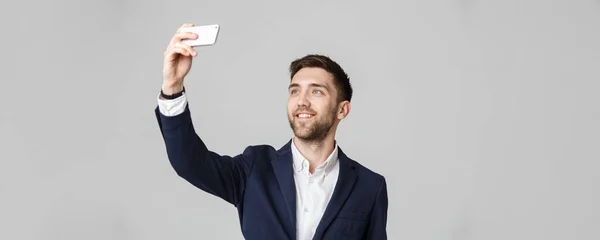 事業コンセプト - ハンサムな実業家は、スマート フォンで自分の selfie を取る。白背景. — ストック写真