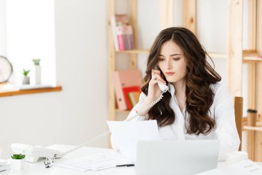 Güzel işkadını bilgisayar ve parlak office bazı iş belgelerde çalışırken kafasına elini tutarak yorgun