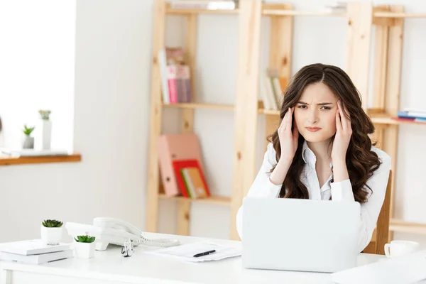 Cansada jovem empresária sofrendo de muito tempo sentado na mesa de computador no escritório — Fotografia de Stock