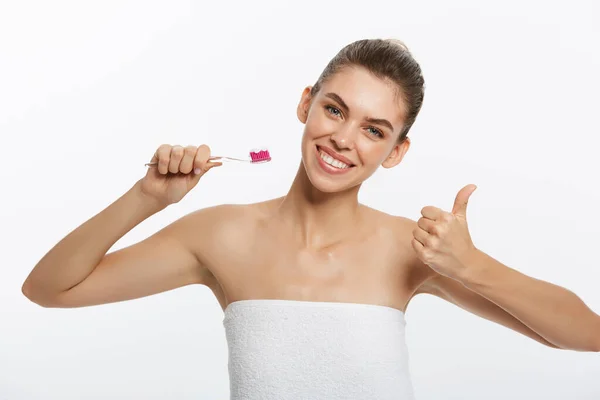 Bellezza ritratto di una felice bella donna mezza nuda lavarsi i denti con uno spazzolino da denti e guardando la fotocamera isolata su sfondo bianco — Foto Stock
