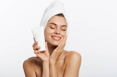 Beyaz bir arka plan üzerinde omuz krem uygulayarak kadın.
