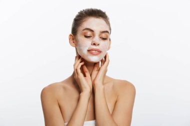 Bir kadının yüzünü uzağa arıyorsunuz üzerinde uygulanan kozmetik yüz maskesi ile yakın.