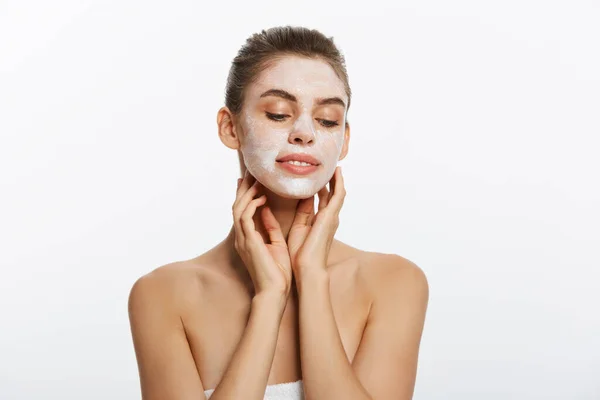 Primo piano di una donna con maschera cosmetica per il viso applicata sul suo viso guardando altrove . — Foto Stock