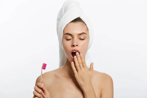 Uśmiechnięta kobieta szczotkowanie zębów z ręcznikiem na głowie. Piękny uśmiech — Zdjęcie stockowe