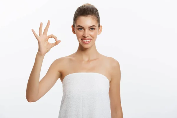 Annons-konceptet. Porträtt av snygg trendig modell efter dusch med gestikulerande ok symbol isolerad på vit bakgrund — Stockfoto