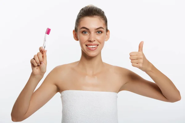 Beauty portrait of a happy beautiful half naked woman brushing her teeth with a toothbrush and looking at camera isolated over white background — Stock Photo, Image
