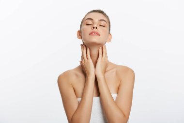 Güzel beyaz bir kadın beyaz bir arka plan karşı havlu ile.