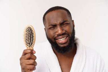 Banyoda saçını tarayan yakışıklı, Afro-Amerikan bir adamın portresi. Beyaz arkaplan üzerinde izole edilmiş