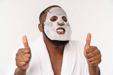 Yüzünde kağıt maskesi olan genç bir adam açık bir ağız ile şok görünümlü, beyaz bir arka planda izole.