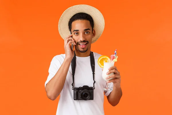리조트등 휴가중인 아프리카 미국인 칵테일을 마시고 친구에게 전화를 스마트폰을 카메라를 — 스톡 사진