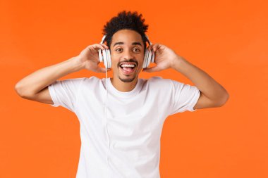 Mutlu ve yakışıklı Afro-Amerikan adam, kulaklıkla müzik dinle, sanatçının yeni single 'ının keyfini çıkar, kamera sorgusuna bak biri onu çağırırken, kalkış kulaklığı takıyor..