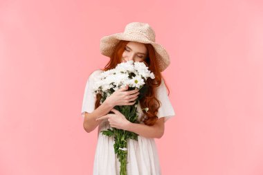 Romantizm, aşk ve ilişki kavramı. Romantik, rüya gibi, kızıl saçlı, çiçekleri koklayan, gözlerini kapatan, güzel buketleri kucaklayan, pembe arka planda duran bir kız. Boşluğu kopyala