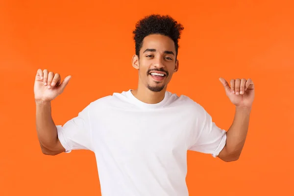 又酷又时髦 自吹自擂的非洲裔美国男人 有纹身 用大拇指指着自己 面带微笑 自信自信 自豪自己的成就 橙色背景 — 图库照片