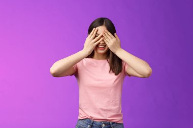 Emri bekleyen kız gözlerini aç kıkır kıkır kıkır kıkır kıkır gülümse, gözlerini kapat, parmaklarının arasından bak, güzel bir sürpriz bekle, neşe içinde gül, hediye bekle, mor arka planda dur.