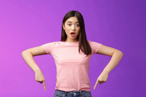ショックを受けた動揺かわいいアジアの驚きの少女 ドロップ顎を横に振った失望し 失望を指して息を吹き 下の広告 否定的な意見 紫の背景を示す — ストック写真
