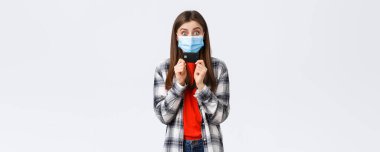 Coronavirus salgını, evden çalışma, online alışveriş ve temassız ödeme konsepti. Neşeli, mutlu, sağlık maskeli güzel bir kadın kredi kartı gösteriyor, gülümsüyor beyaz arka plan.