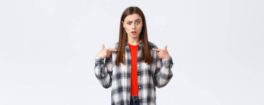 Yaşam tarzı, farklı duygular, boş zaman aktiviteleri konsepti. Kafası karışmış genç bir kız neden o olduğunu anlayamaz. Kafası karışmış bir kadın kaşlarını kaldırmış, seçilmiş, beyaz bir altyapısı var..