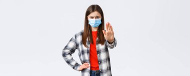 Coronavirus salgını, karantina, sosyal mesafeler ve duygu kavramı. Tıbbi maskeli genç bir kadın hayal kırıklığına uğramış, onaylanmamış görünüyor..
