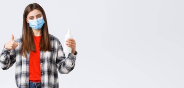 Coronavirus salgını, karantina, sosyal mesafeler ve duygu kavramı. Tatmin olmuş kadın müşteri, tıbbi maske takan müşteri bu el sabunu ya da el dezenfektanı, baş parmak yukarı..