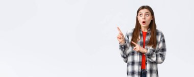 Yaşam tarzı, farklı duygular, boş zaman aktiviteleri konsepti. Çekici bir kız, Avrupalı bir kadın gömleği işaretli ve sol üst köşeye bakıyor, müthiş bir tanıtıma dikkat çekiyor..