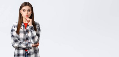 Yaşam tarzı, farklı duygular, boş zaman aktiviteleri konsepti. Akıllı kadın, günlük kıyafet arayışı çözeltisi düşünüyor, bakıyor, karar verirken çeneye dokunuyor, seçim yapıyor..