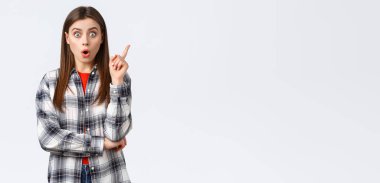 Yaşam tarzı, farklı duygular, boş zaman aktiviteleri konsepti. Heyecanlı zeki kızın harika bir fikri var, planı paylaşın, işaret parmağı önerisini söyleyin ve derin düşüncelere dalın..