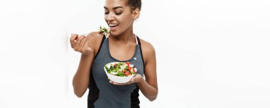 Sağlıklı ve Fitness kavramı - taze salata yemek diyet fitness giysili güzel Amerikan Afrika Bayan. Beyaz arka plan üzerinde izole