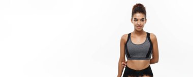 Sağlıklı ve Fitness konsepti. Spor için hazır spor elbiseli güzel Amerikalı Afrikalı bayan. Beyaz arkaplanda izole