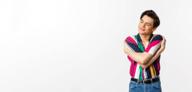 Mutlu genç adam, gözleri kapalı, gülümseyen, mutlu, bir şeyin hayalini kuran, beyaz arka planda duran..