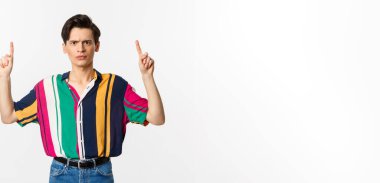 Hayal kırıklığına uğramış ve öfkeli bir adam kötü bir şey göstererek beyaz arka planda duruyor. Boşluğu kopyala