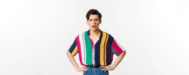 Kafası karışmış ve üzgün genç bir adamın beyaz arka planda hayal kırıklığına uğramış bir şekilde kameraya bakması..