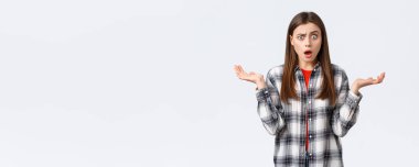 Yaşam tarzı, farklı duygular, boş zaman aktiviteleri konsepti. Şaşırmış ve şaşırmış genç bir kadın nefes nefese, yere düşmüş ve büyük haberlerden ürkmüş, ellerini yana açmış, beklenmedik bir durum..