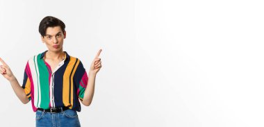 Yakışıklı eşcinsel adam iki farklı türü gösteriyor, tanıtım yapıyor, beyaz arka planda duruyor..