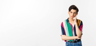 Çekici genç bir adamın beyaz arka planda durarak isteksiz ve rahatsız edici duygularla kameraya baktığı görüntüler..