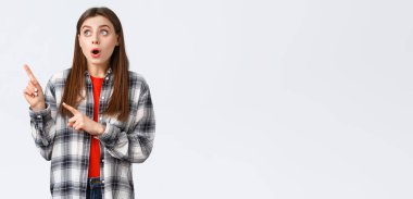 Yaşam tarzı, farklı duygular, boş zaman aktiviteleri konsepti. Çekici bir kız, Avrupalı bir kadın gömleği işaretli ve sol üst köşeye bakıyor, müthiş bir tanıtıma dikkat çekiyor..