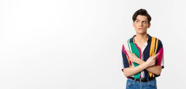 Kararsız yakışıklı bir adamın portresi seçim yapıyor, parmaklarını yana doğru gösteriyor ve düşünüyor, beyaz arka planda duruyor..