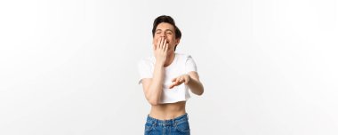 Lgbtq ve gurur konsepti. Ekin giymiş aptal bir gay adamın görüntüsü kameraya bakıp gülüyor, komik şakalara gülüyor, beyaz arka plan.