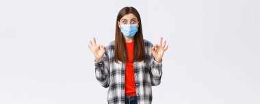 Coronavirus salgını, karantina, sosyal mesafeler ve duygu kavramı. Heyecanlı ve şaşırmış genç bir kadın iyi olduğunu gösteriyor. Gerçekten iyi bir reklam, tıbbi maske takın..